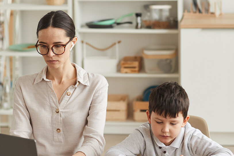 mamma som sitter i möte bredvid sin son