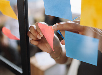 post-it lappar sätts upp på en glasvägg